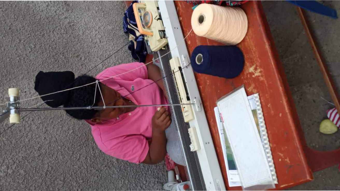 Me in the picture operating the knitting machine we received from TOOLS WITH A MISSION U.K